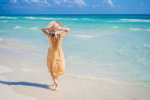 Happy traveller woman in yellow dress enjoys her tropical beach vacation. GO Everywhere.