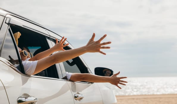 Close up of hands. Happy family sitting in the car waving hands travel outside car windows going to beach for travel, People having fun outdoors on road trip, vacation holiday