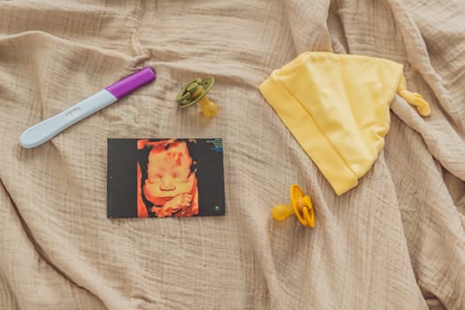 A composition of essential pregnancy attributes: a positive pregnancy test, ultrasound image, tiny pacifier, and a soft baby's cap, embodying the journey to motherhood.