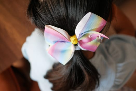 Beautiful ribbon is tied on a child hair .