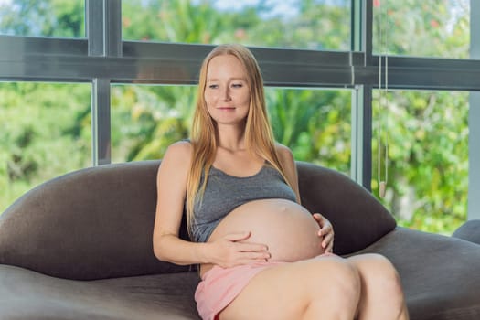 Young pregnant woman relaxing in the room.