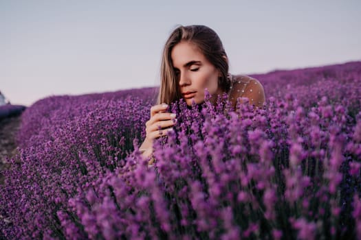 Close up portrait of young beautiful woman in a white dress and a hat is walking in the lavender field and smelling lavender bouquet.