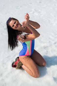 Caucasian woman in a swimsuit sunbathes on the snow in winter