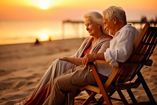 Happy retired couple relaxing on sun loungers near the seashore at sunset. High quality photo