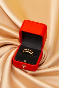 Golden ring in red jewelry box close up studio shot