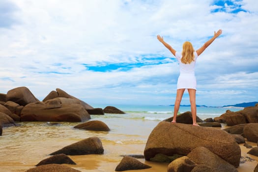 Woman with opened hands near the ocean
