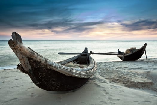 Two fisherman boats at sunrise time on the beach
