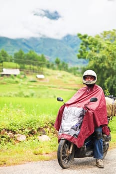 Rider on motobike at rainy day. Rural countryside