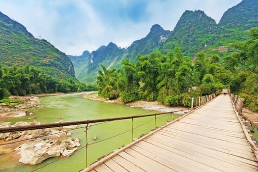 Wooden bridge over mountain river. Northern Vietnam