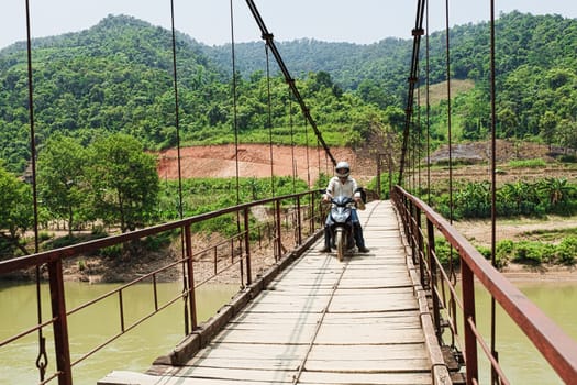 Wooden bridge over mountain river. Northern Vietnam