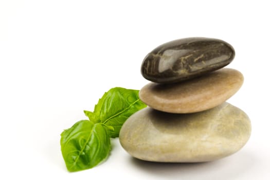 A stack of three pebbles and green leaves