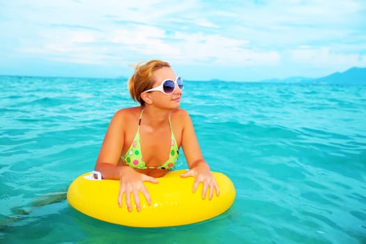 Funny woman with yellow tube in the sea