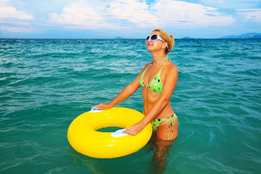 Funny woman with yellow tube in the sea
