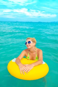 Funny woman with life buoy in the ocean