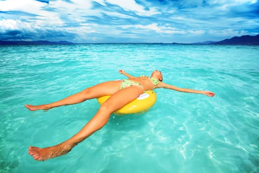 Woman relaxing with life buoy in the ocean