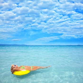 Woman relaxing on the tube in clean blue ocean