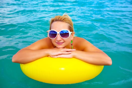 Funny woman with yellow tube in the sea
