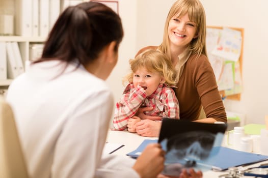 Young woman with little daughter having consultation at pediatrician office