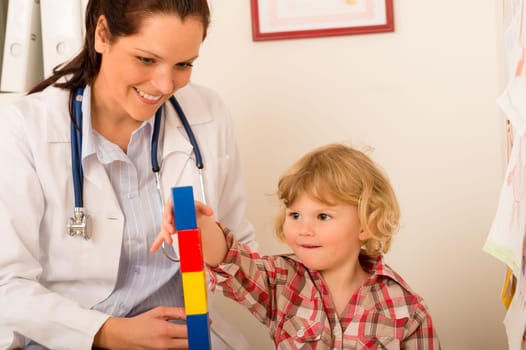Female pediatrician playing with little girl at medical office