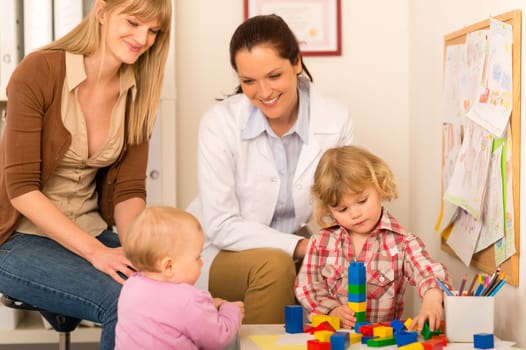 Visit at pediatrician two little children play at medical office