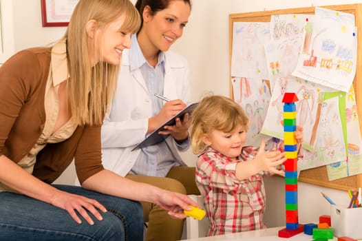 Visit at pediatrician with little child girl play at medical office
