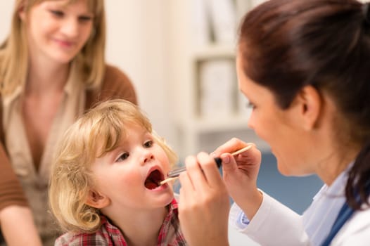 Little girl having throat examination by pediatrician using light pen