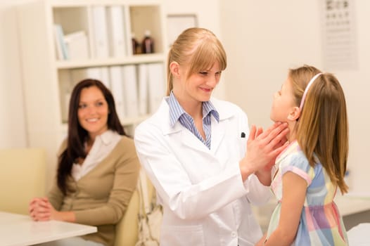 Little girl having throat examination by pediatrician using light pen