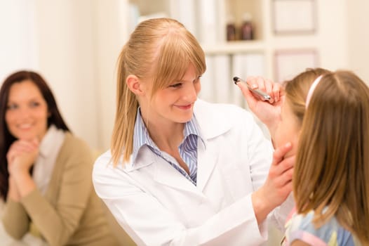 Female pediatrician doing eye check-up to little girl