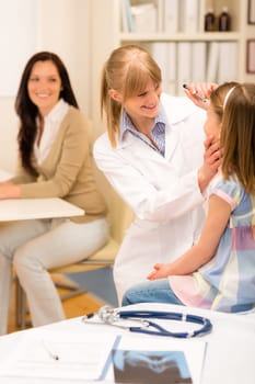 Female pediatrician doing eye check-up to little girl