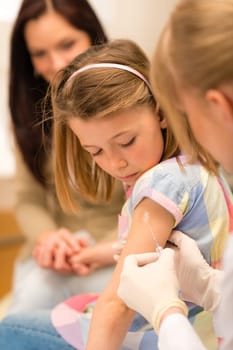 Little girl getting vaccination from pediatrician at medical office