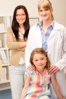 Portrait of little girl with pediatrician and mother in background