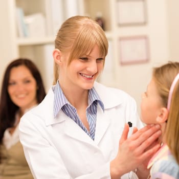 Little girl having throat examination by pediatrician using light pen