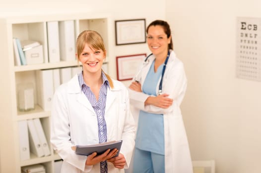 Portrait of two female doctors standing at medical office together