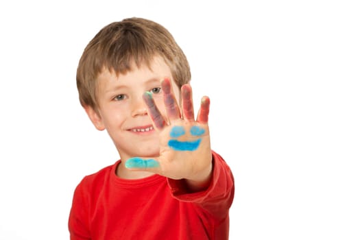 Boy paints a face on his hand with finger paints