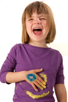 Girl paints a face on her sweater with finger paints