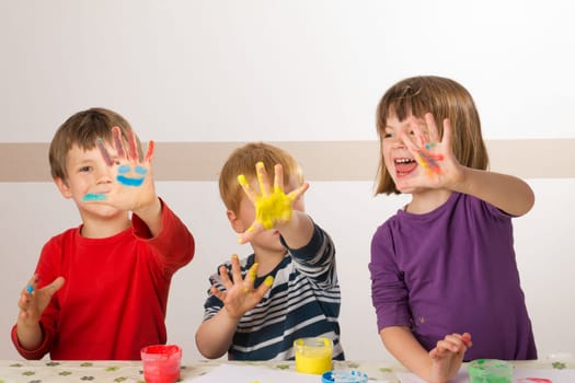 Children paint with finger paints and have fun doing it