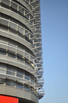 Office building behind the blue sky. The building has a gray glass facade with aluminum panels and visors. Prague, Czech Republic