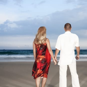 Young loving couple looking to the sea