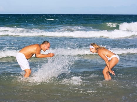 Young couple have a fun time on the tropical beach.
