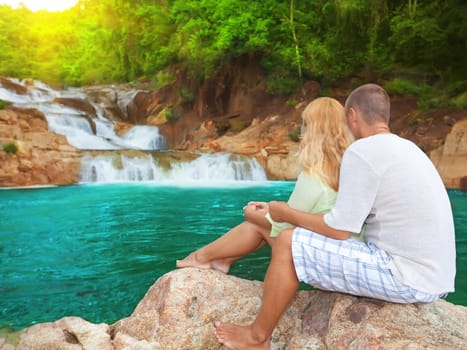Couple near waterfall on sunrise time