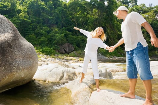 Young couple have a fun time near mountain river