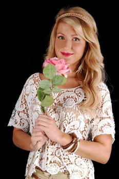 A portrait shot of a gorgeous young woman with long curly blond  hair, holding a pink rose, for black background.