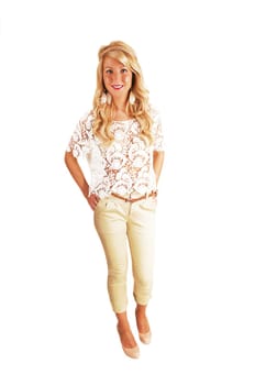A young pretty woman in a beautiful blouse and beige pants standing with her long curly blond hair for white background.