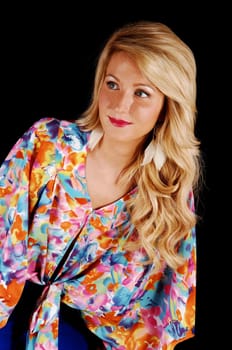 A portrait of a beautiful young blond woman in a colorful blouse and  nice curly hair, for black background.
