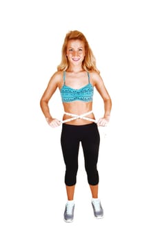 A lovely slim woman measuring her stomach after her exercise, with her long curly blond hair, for white background.