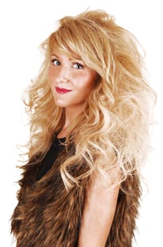 A portrait of a young woman in a fur top and long curly blond hair, looking into the camera, for white background.