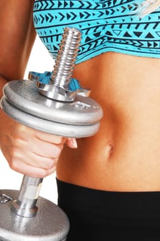 A closeup picture of the stomach of a young woman in a sports bra and black pants with dumbbell&#039 s in her hand, over white.