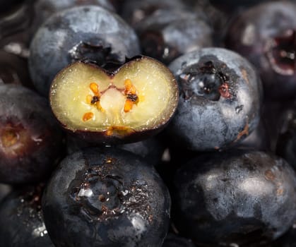 Stack of blueberries with one sliced through the center to show seeds