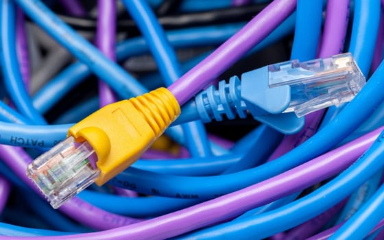 Macro shot of plugs on cat5e cables of many colors on top of tangle of wires