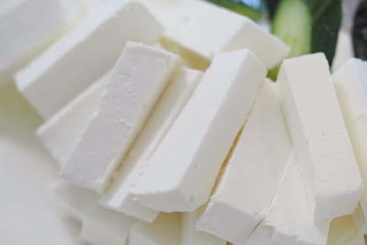 Soft white cheese is neatly arranged, showcasing its creamy texture and shape.